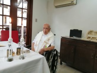 padre Luis Rojas en su cumpleaños 100 con una mesa